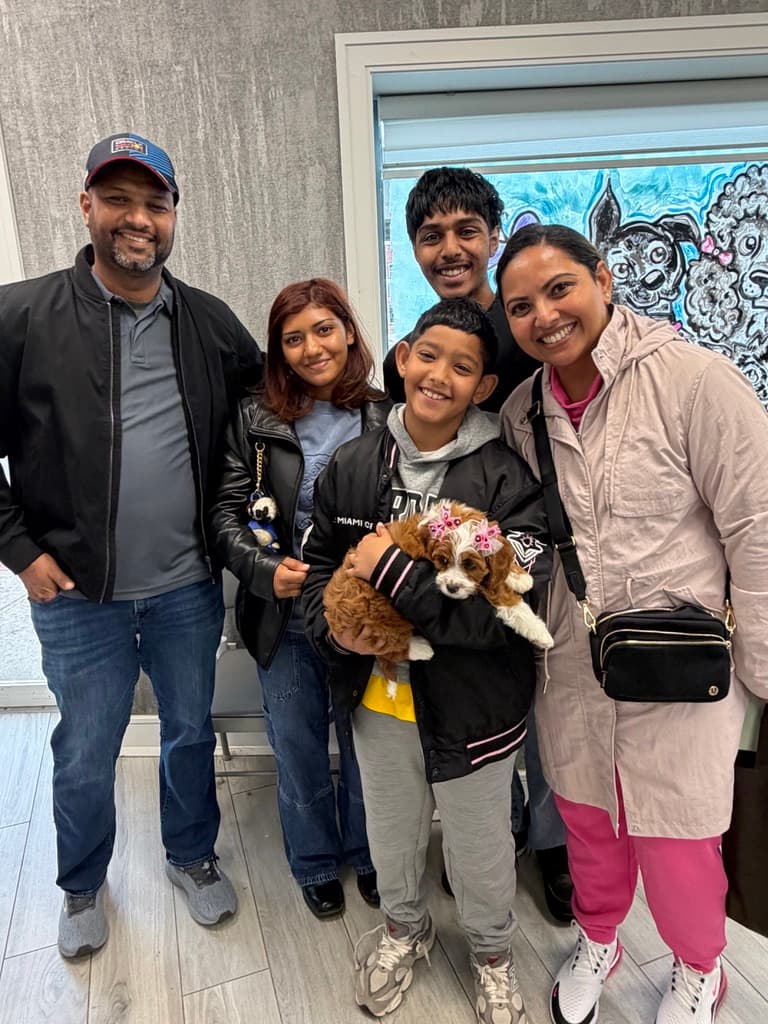 A family picking up their new Cavapoo puppy