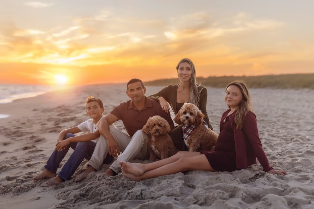 Fran and her family at the beach at sunset with their Cavapoos