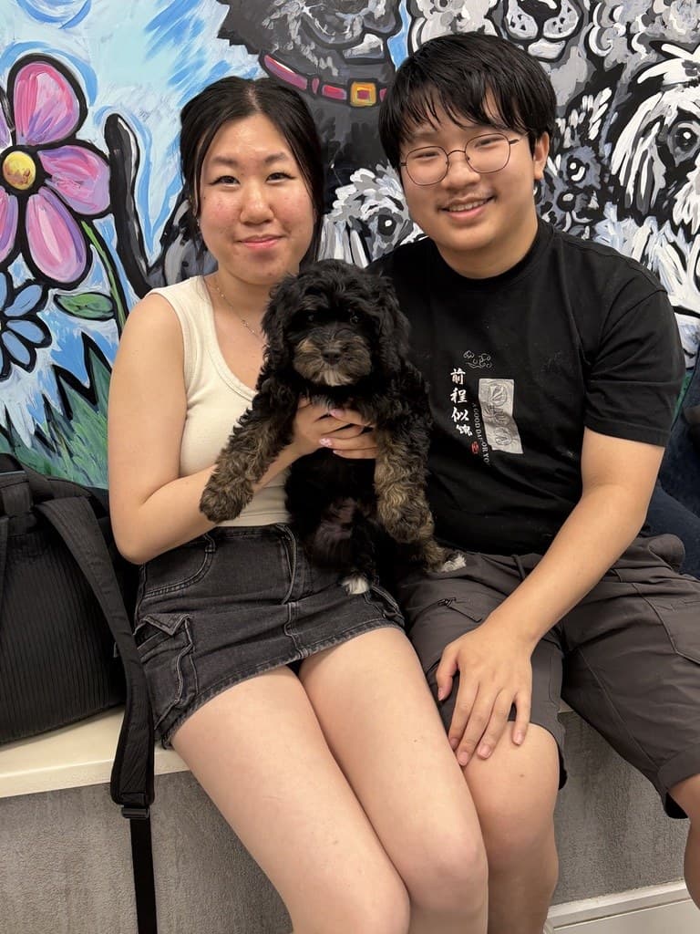 A couple with their new puppy on pickup day