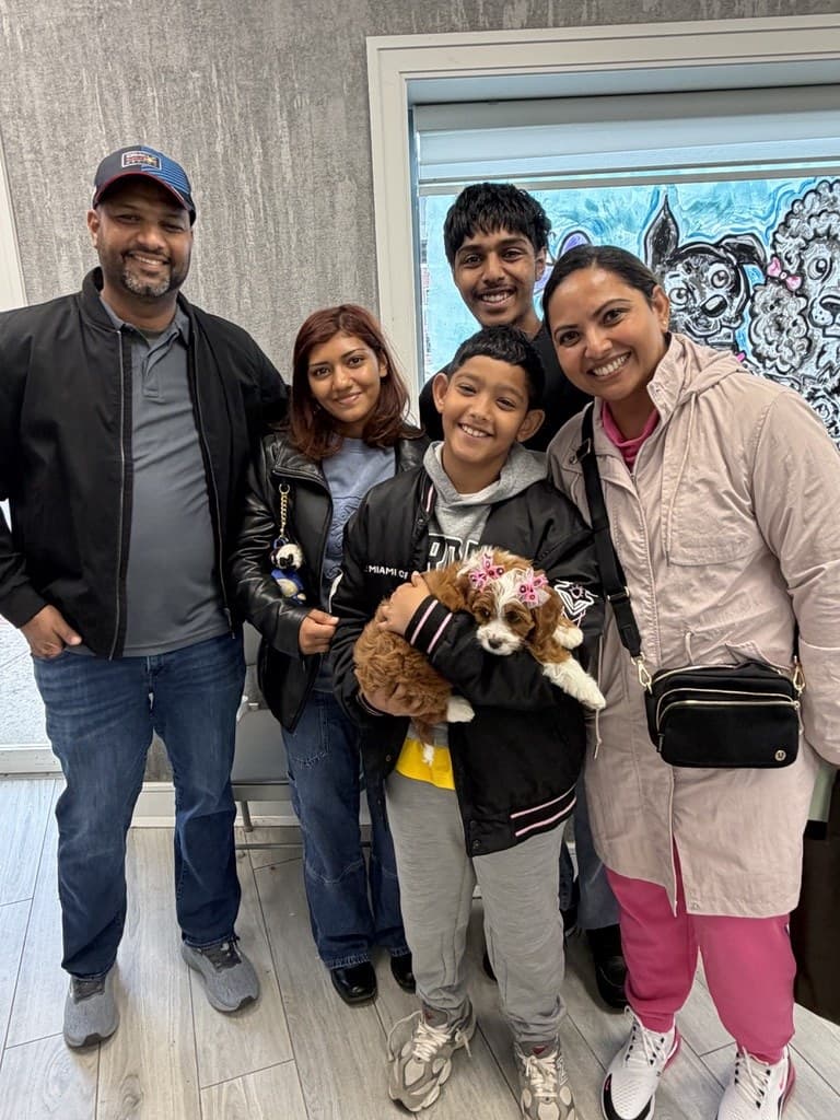 A family at puppy pickup day with their new Cavapoo